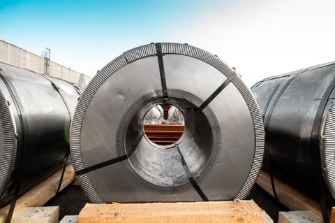 Entrepôt industriel extérieur avec bobines d'acier galvanisé stockées sur palettes en bois