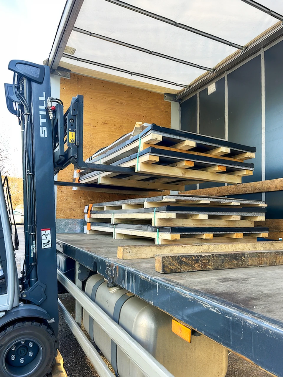 Chargement d'un camion fourgon par un chariot élévateur électrique **STILL** équipé d'un mât télescopique