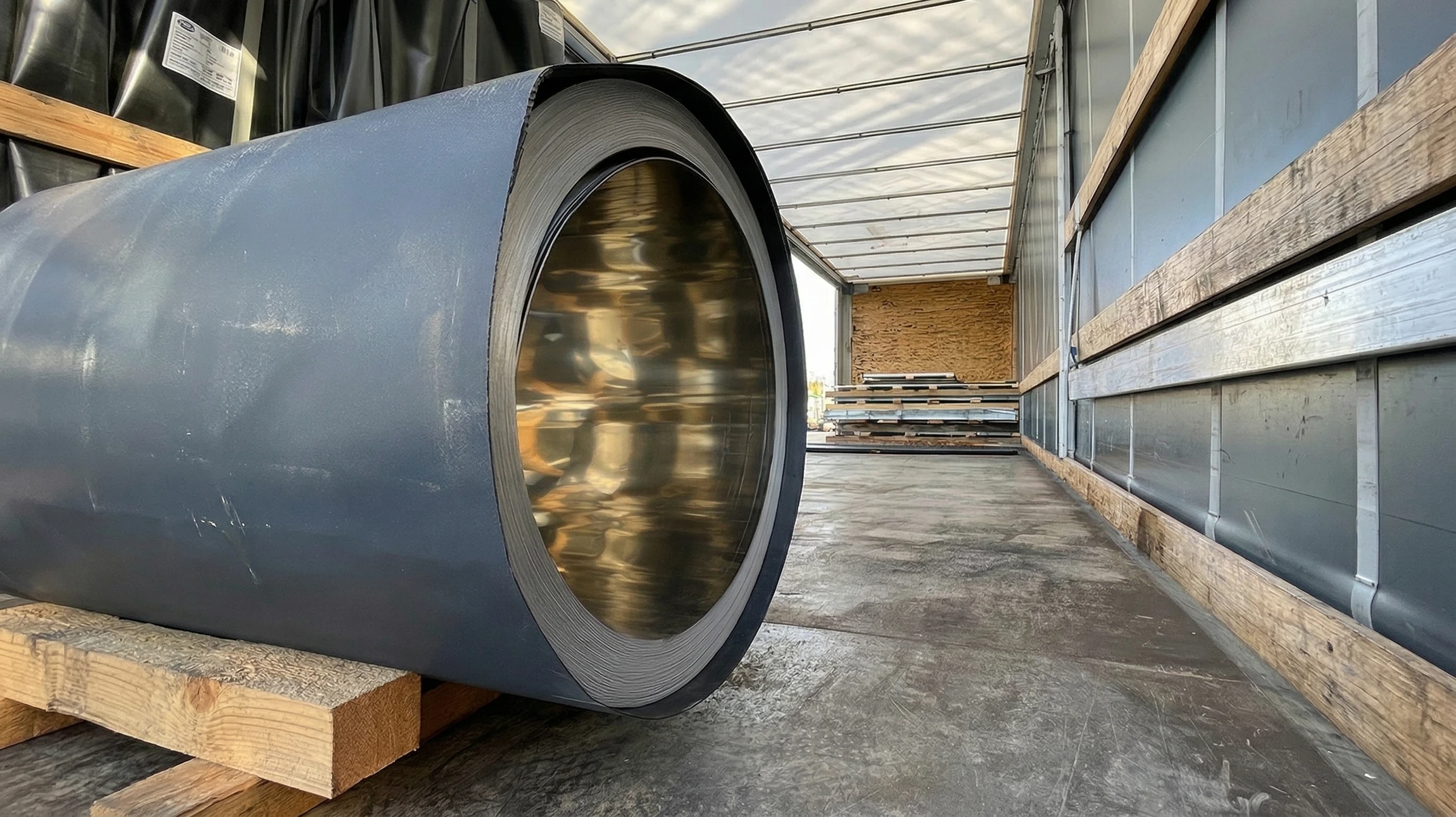 Deux livreurs en uniformes bleus transportent des colis en carton ondulé devant un véhicule utilitaire blanc